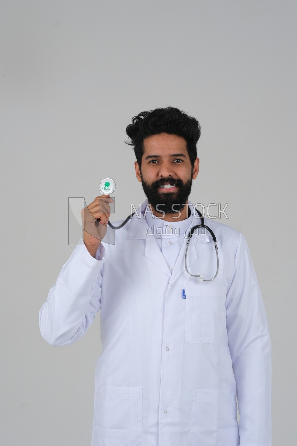 Saudi man wearing a medical coat and a stethoscope, white background, medicine and health care, Saudi model
