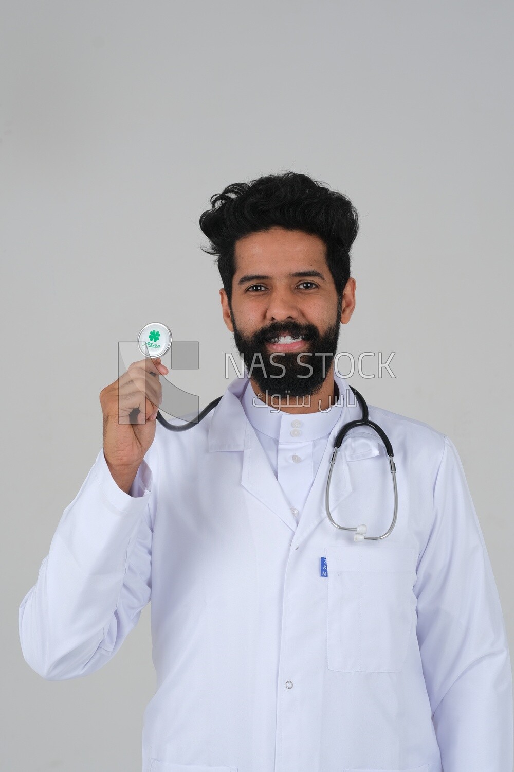 Saudi man wearing a medical coat and a stethoscope, white background, medicine and health care, Saudi model