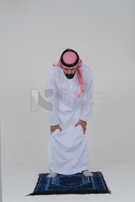 سعودي يرتدي الثوب الأبيض والشماغ ويصلي على سجادة الصلاة ، يدعو الله ، الإسلام والعبادة ، خلفية بيضاء ، موديل سعودي