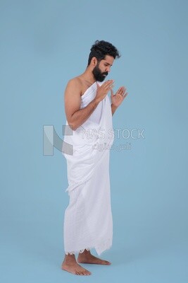 Saudi man wearing the Ihram dress, praying on the prayer rug, praying to god, Islam and worship, performing Hajj and Umrah, remembrances and supplications, Saudi model