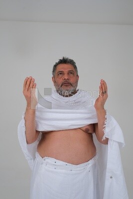 رجل سعودي يلبس لباس الاحرام ويرفع يديه للدعاء لله  ، الاسلام والعبادة ،  ويؤدي الحج والعمرة ، اذكار وادعية ، خلفية بيضاء ، موديل سعودي.