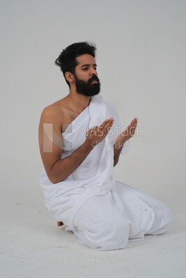 جانب رجل سعودي يلبس لباس الاحرام ويرفع يديه للدعاء لله  ، الاسلام والعبادة ،  ويؤدي الحج والعمرة ، اذكار وادعية ، خلفية بيضاء ، موديل سعودي.
