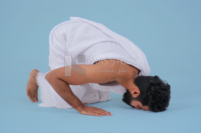 Saudi man wearing the Ihram dress, praying on the prayer rug, praying to god, Islam and worship, performing Hajj and Umrah, remembrances and supplications, Saudi model