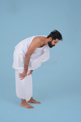 the side of a Saudi man wearing the Ihram dress, praying on the prayer rug, praying to god, Islam and worship, performing Hajj and Umrah, remembrances and supplications, Saudi model