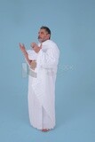 Side of a Saudi man wearing the Ihram dress and raising his hands to supplicate to God, Islam and worship, performing Hajj and Umrah, remembrances and supplications, Saudi model