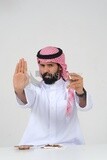 Saudi man fights against the smoking habit, gestures indicating stopping, tobacco addiction, cigarette addiction, harmful and toxic substance abuse, harmful behavioral habits, no smoking, Saudi model