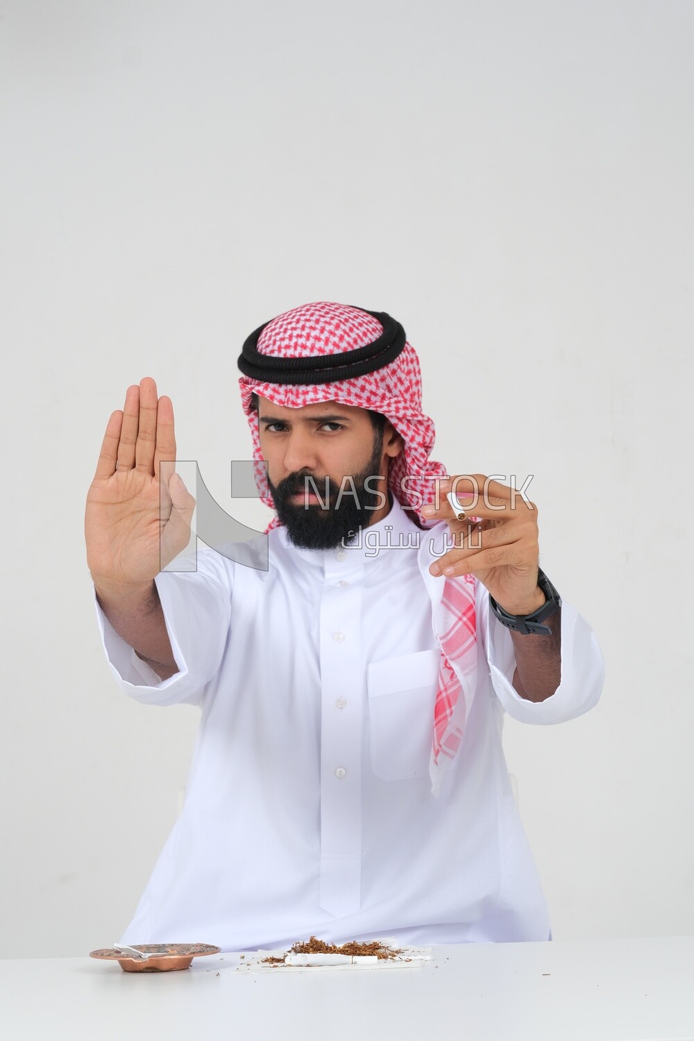 Saudi man fights against the smoking habit, gestures indicating stopping, tobacco addiction, cigarette addiction, harmful and toxic substance abuse, harmful behavioral habits, no smoking, Saudi model