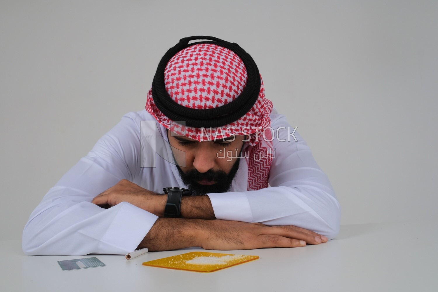 Saudi man sitting in front of many types of toxic substances, tobacco addiction, cigarette addiction, harmful and toxic substance abuse, harmful behavioral habits, no smoking, Saudi model