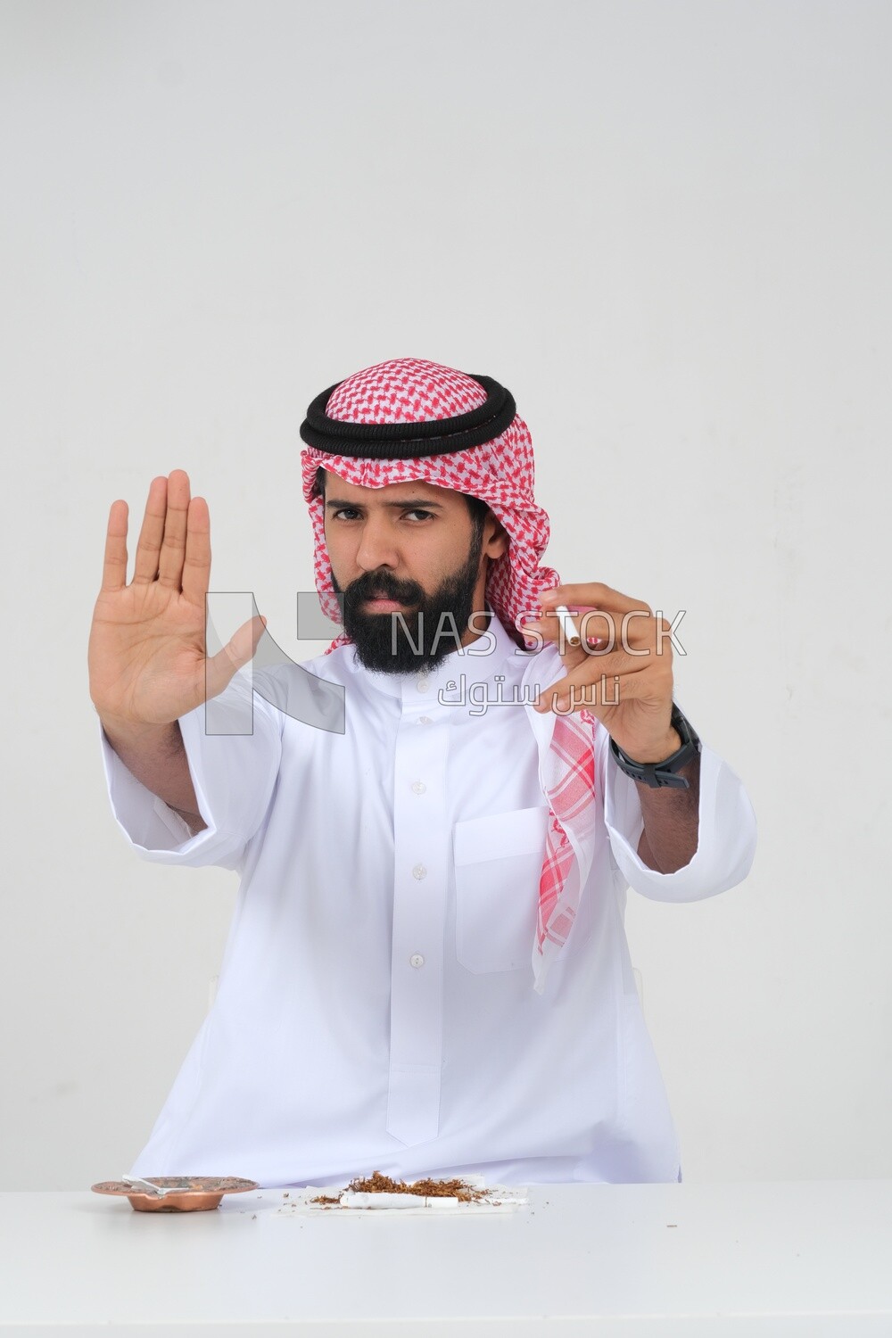 Saudi man fights against the smoking habit, gestures indicating stopping, tobacco addiction, cigarette addiction, harmful and toxic substance abuse, harmful behavioral habits, no smoking, Saudi model