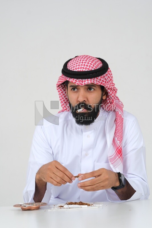 Saudi man wrapping cigarettes with his hands, tobacco addiction, cigarette addiction, harmful and toxic substance abuse, harmful behavioral habits, no smoking, Saudi model