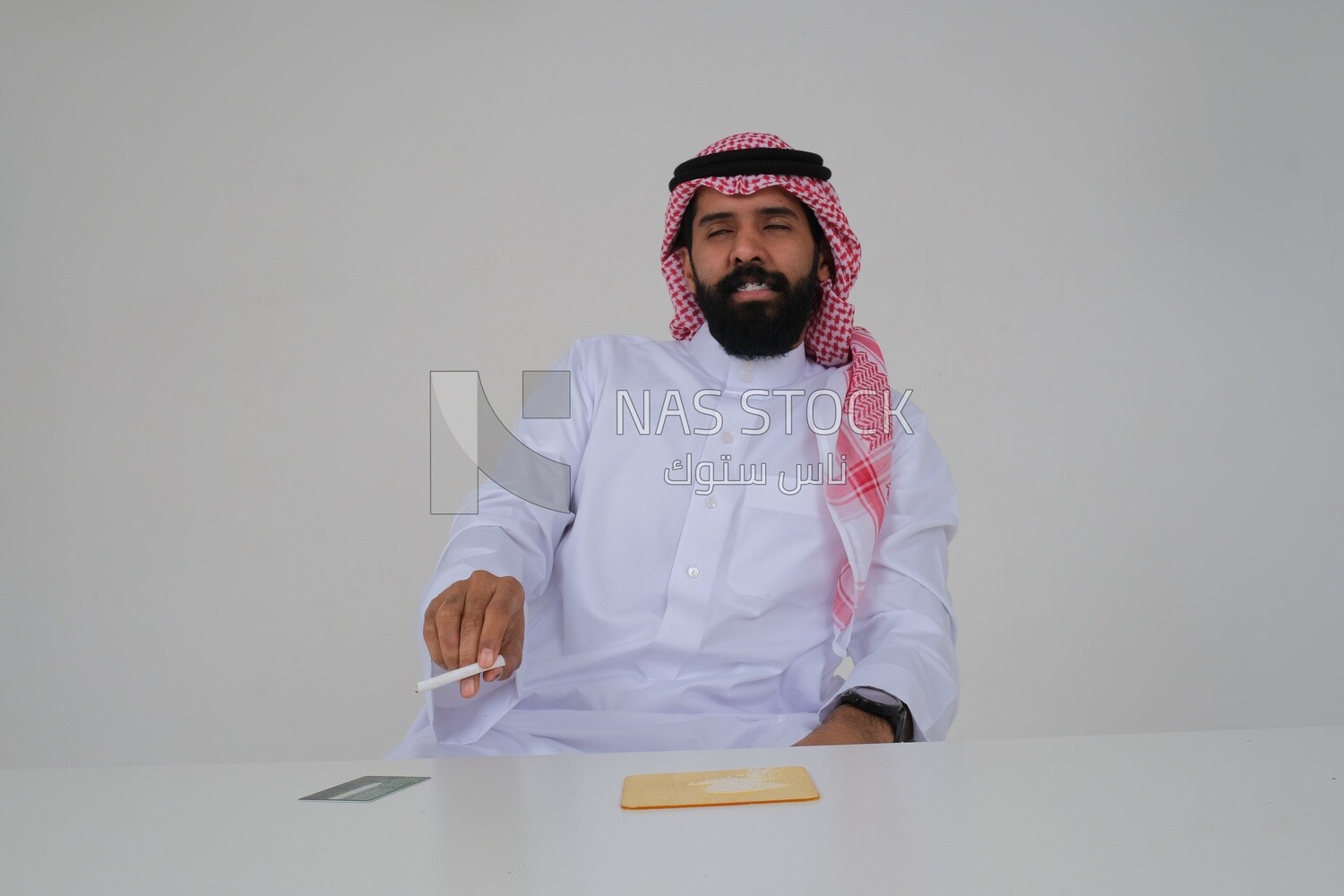 Saudi man wearing a white thobe and shemagh takes a deep breath from a cigarette, tobacco addiction, cigarette addiction, harmful and toxic substance abuse, harmful behavioral habits, no smoking, Saud