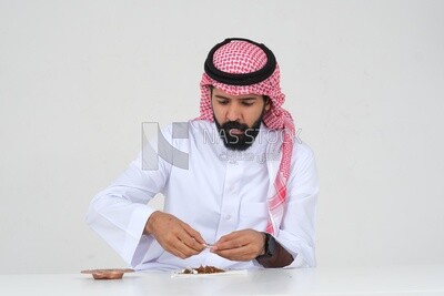 رجل سعودي يلف السجائر بيديه ، إدمان التبغ ، إدمان السجائر ، تعاطي مواد ضارة و سامة ، عادات سلوكية ضارة ، ممنوع التدخين ، موديل سعودي