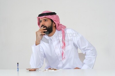 Saudi man wearing a white thobe and shemagh takes a deep breath from a cigarette, tobacco addiction, cigarette addiction, harmful and toxic substance abuse, harmful behavioral habits, no smoking, Saud