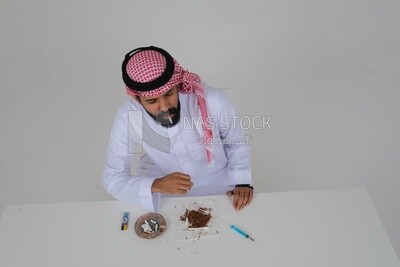 Saudi man wearing a white thobe and shemagh takes a deep breath from a cigarette, tobacco addiction, cigarette addiction, harmful and toxic substance abuse, harmful behavioral habits, no smoking, Saud