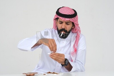 Saudi man wrapping cigarettes with his hands, tobacco addiction, cigarette addiction, harmful and toxic substance abuse, harmful behavioral habits, no smoking, Saudi model