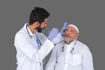 Saudi man wearing a medical coat and a stethoscope, checking the patient&#39;s eyes, white background, medicine and health care, Saudi model