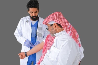 رجل سعودي يلبس المعاطف والقفازات الطبية ويعطي المريض السعودي الحقن ، مفهوم الطب والرعاية الصحية ، ويتلقى التطعيمات في المراكز الصحية ، موديل سعودى