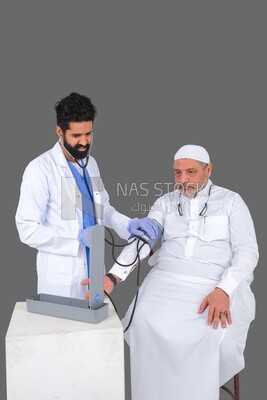 رجل سعودي يرتدي معطفا طبيا وسماعة طبية ، يقيس ضغط المريض ، الخلفية البيضاء ، الطب والرعاية الصحية ، موديل سعودي