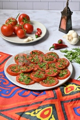 Plate of pickled tomatoes with parsley, besides garlic, red pepper, Egyptian pickles, Arab restaurants