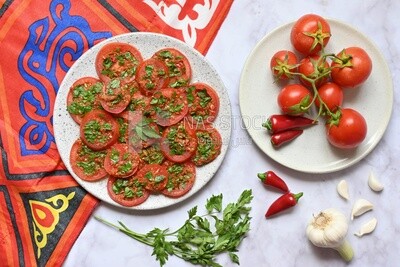 Plate of pickled tomatoes with parsley, besides garlic, red pepper, Egyptian pickles, Arab restaurants