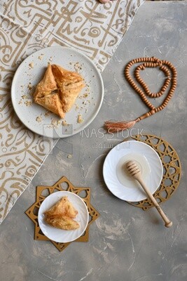 Baklava with nuts, a plate of honey, oriental Arabic sweets, Ramadan sweets