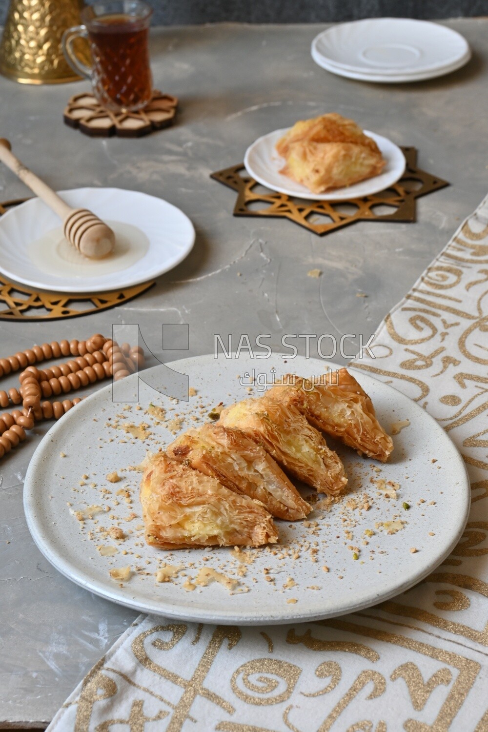 Baklava with cream in it, a cup of tea, a plate of honey, oriental Arabic sweets, Ramadan sweets