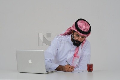 Saudi man sitting in front of a laptop writing notes,  a cup of tea, business feasibility study, white background, Saudi model