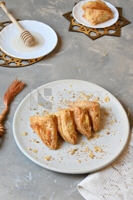 Baklava with cream in it, a plate of honey, oriental Arabic sweets, Ramadan sweets
