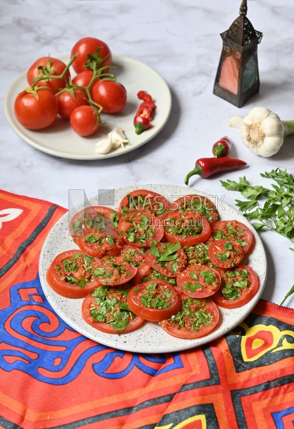 Plate of pickled tomatoes with parsley, besides garlic, red pepper, Egyptian pickles, Arab restaurants