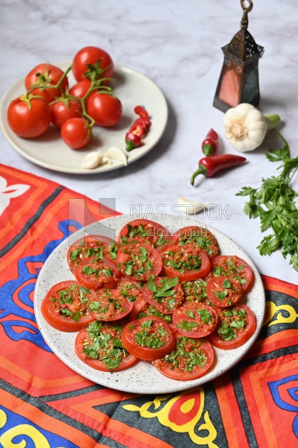 Plate of pickled tomatoes with parsley, besides garlic, red pepper, Egyptian pickles, Arab restaurants