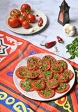 Plate of pickled tomatoes with parsley, besides garlic, red pepper, Egyptian pickles, Arab restaurants