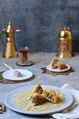 Baklava with nuts, a cup of tea, a plate of honey, oriental Arabic sweets, Ramadan sweets