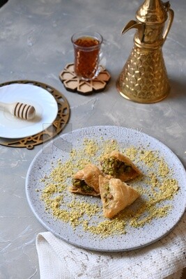 Baklava with nuts, a cup of tea, a plate of honey, oriental Arabic sweets, Ramadan sweets