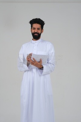 Saudi man taking notes on work papers and files, preparing reports and work tasks, business feasibility study, white background, Saudi model