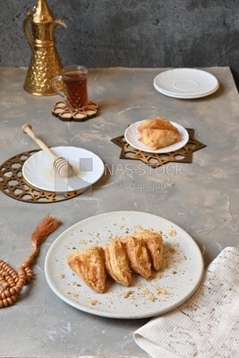 Baklava with nuts, a cup of tea, a plate of honey, oriental Arabic sweets, Ramadan sweets