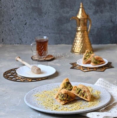 Baklava with nuts, a cup of tea, a plate of honey, oriental Arabic sweets, Ramadan sweets