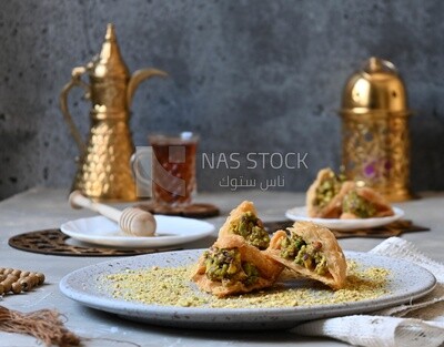 Baklava with nuts, a cup of tea, a plate of honey, oriental Arabic sweets, Ramadan sweets
