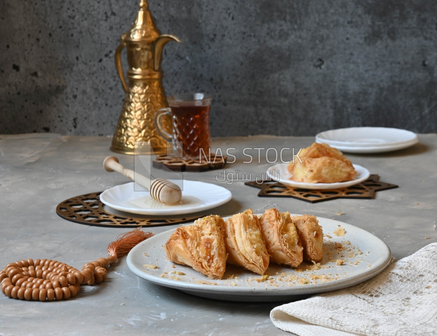 Baklava with cream in it, a cup of tea, a plate of honey, oriental Arabic sweets, Ramadan sweets