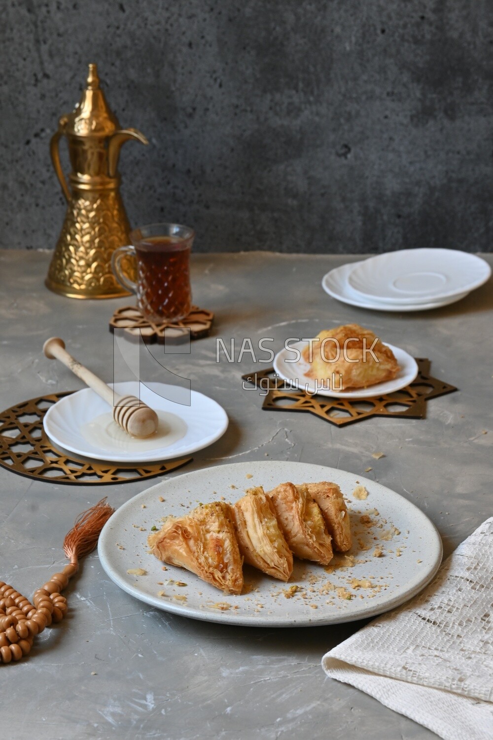 Baklava with cream in it, a cup of tea, a plate of honey, oriental Arabic sweets, Ramadan sweets