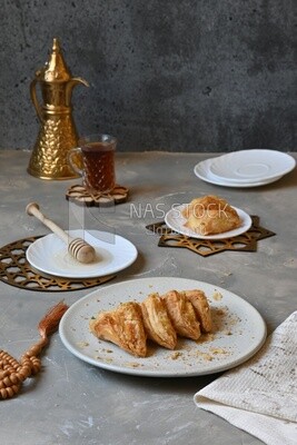 Baklava with cream in it, a cup of tea, a plate of honey, oriental Arabic sweets, Ramadan sweets