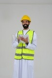 Saudi engineer wearing a work helmet and protective jacket, writing and taking notes, engineering professions and jobs, white background, Saudi model