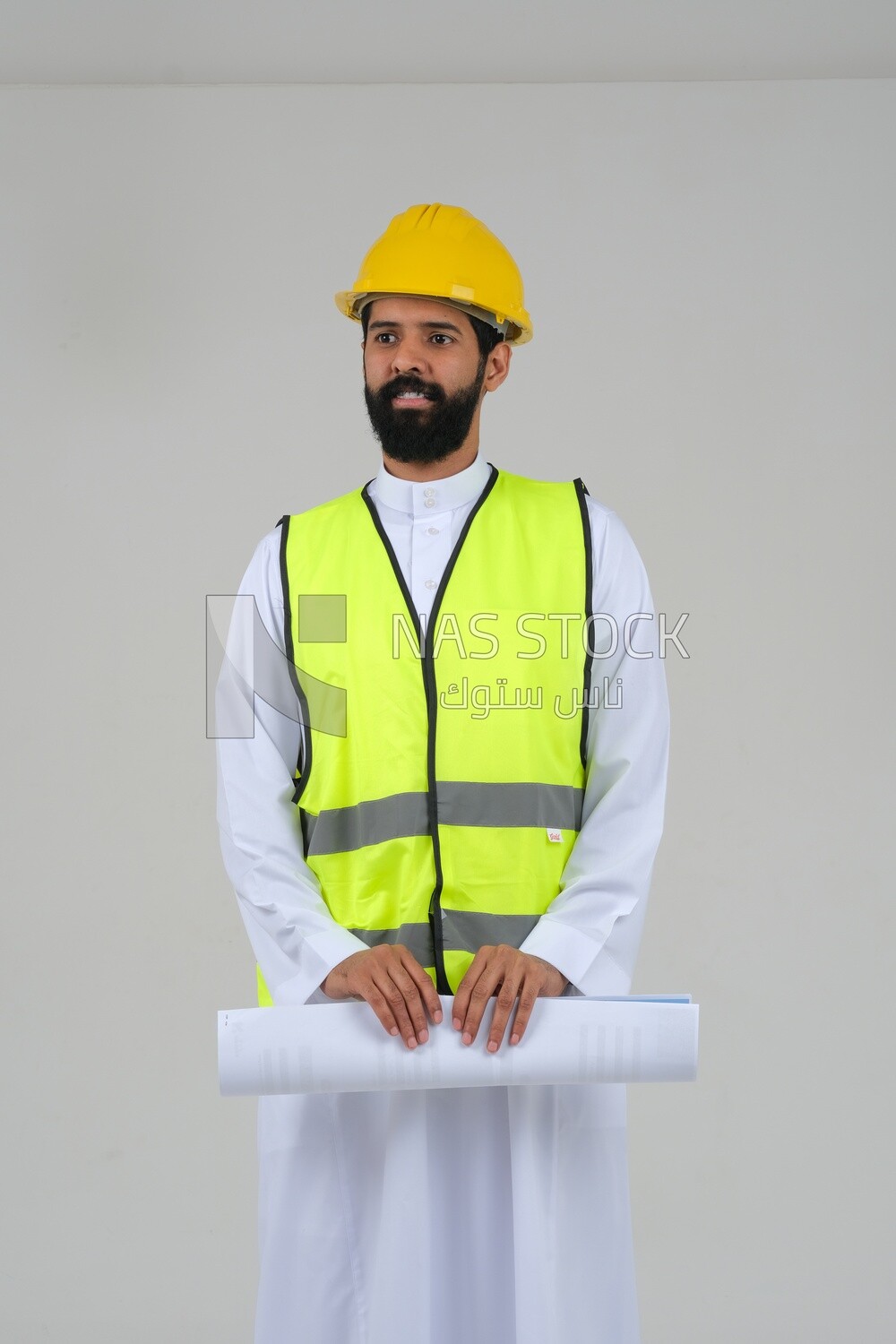 Saudi engineer wearing a work hat and safety vest, holding in his hand the construction plan, engineering professions and jobs, white background, Saudi model