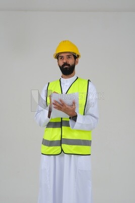 Saudi engineer wearing a work helmet and protective jacket, writing and taking notes, engineering professions and jobs, white background, Saudi model