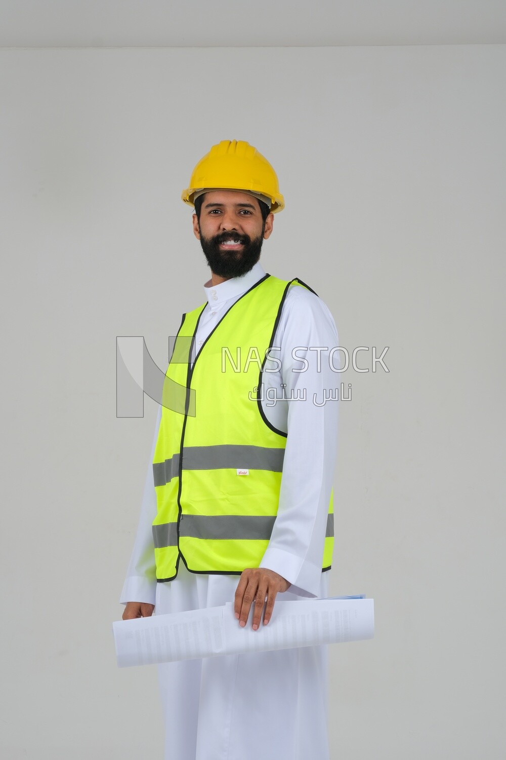 saudi engineer wearing a work hat and safety vest, holding in his hand the construction plan, engineering professions and jobs, white background, Saudi model