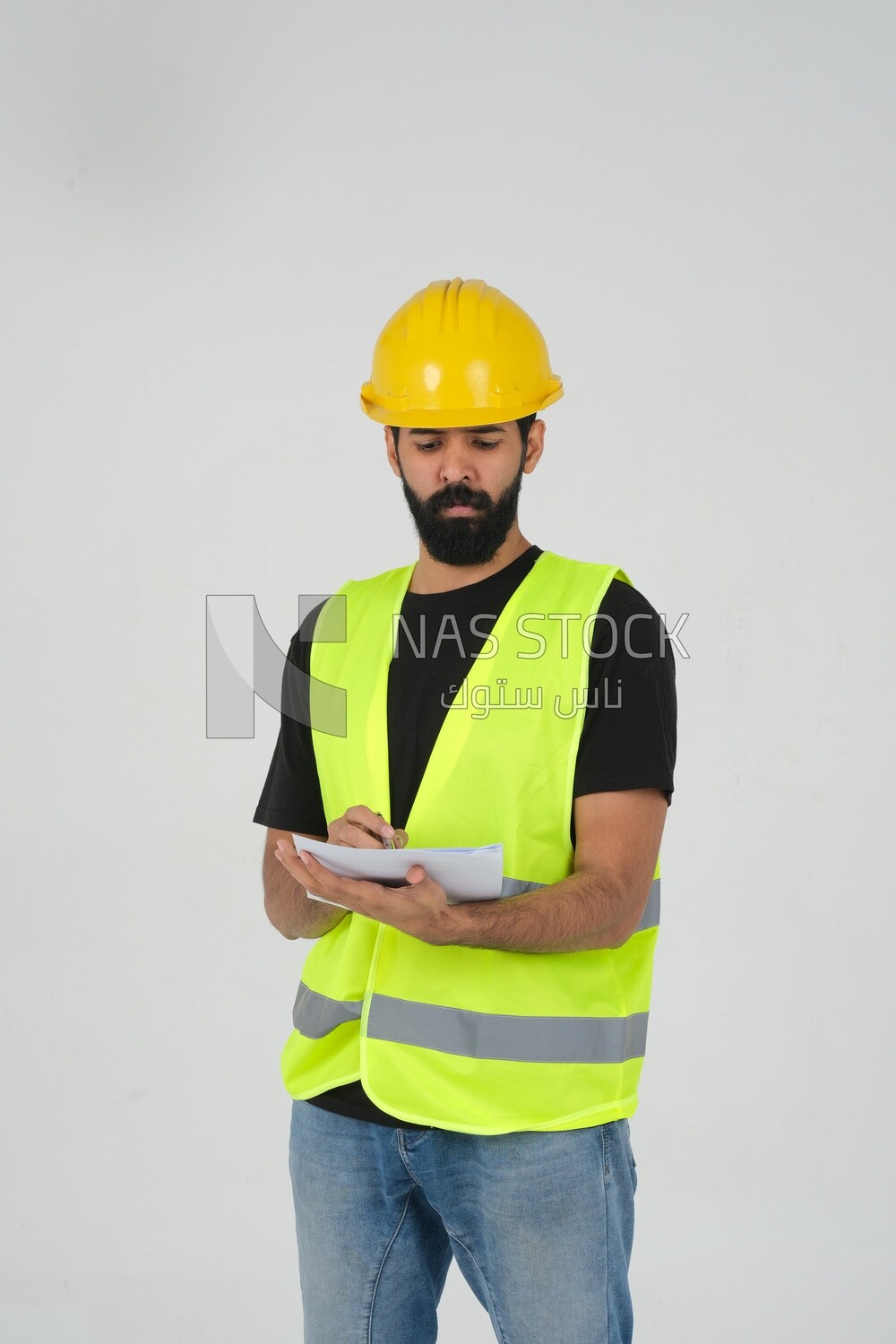 Saudi engineer wearing a work helmet and protective jacket, writing and taking notes, engineering professions and jobs, white background, Saudi model