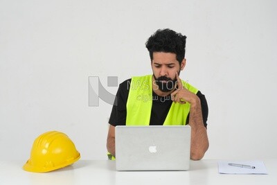 Saudi engineer, sitting and working on the laptop, a cup of tea, work hat, engineering professions and jobs, white background, Saudi model