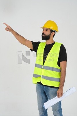 Saudi engineer wearing a work hat and safety vest, holding in his hand the construction plan pointing away, engineering professions and jobs, white background, Saudi model