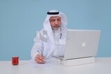 Saudi man sitting in front of a laptop writing notes,  a cup of tea, business feasibility study, white background, Saudi model