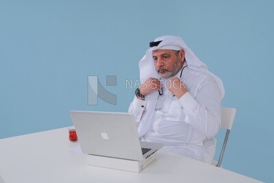 Saudi man sitting and working on a laptop, a cup of tea, business feasibility study, Saudi model