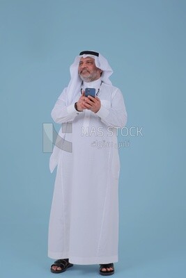 elderly Saudi man using a mobile phone, communicating with individuals, online requests and marketing, social relations, using technical devices